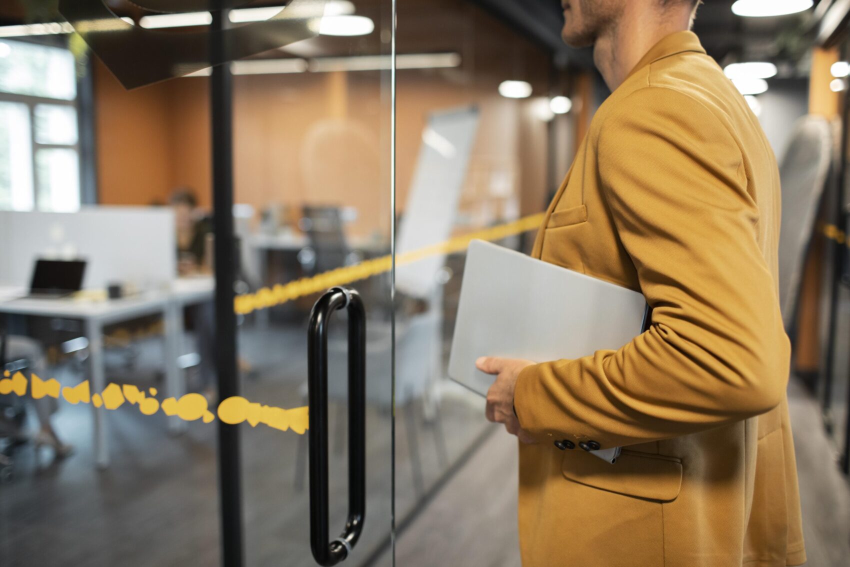 Hombre señalando un portátil cerrado, representando la garantía de confidencialidad de la información en la empresa.