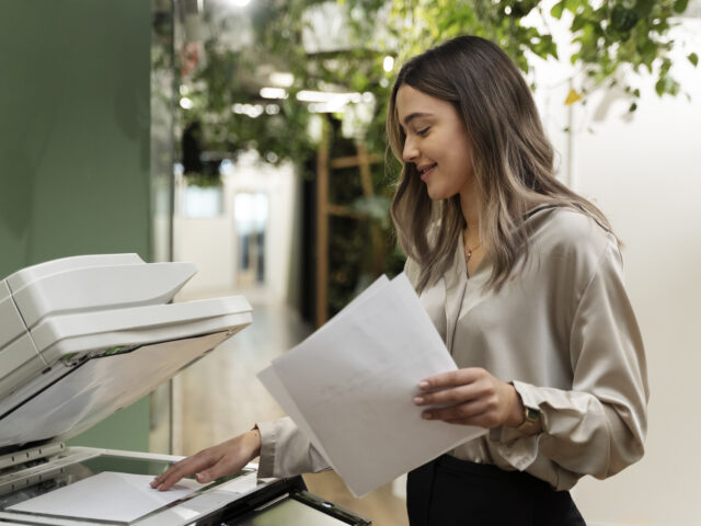 Mujer sonriente sosteniendo un documento listo para escanear o imprimir