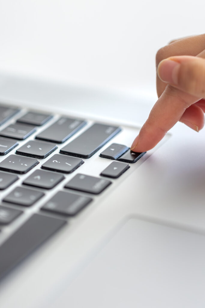 La chica escribe en el teclado de la laptop. Sus manos están sobre el teclado. Foto de alta calidad. Primer plano de las manos. Comunicación en línea a través de la laptop.